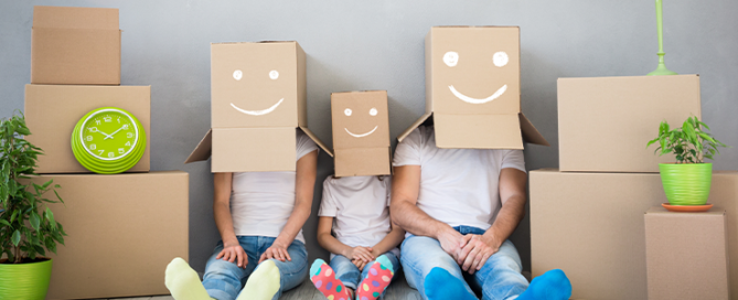 Happy family playing into new home. Father, mother and child having fun together. Moving house day and "think outside the box"